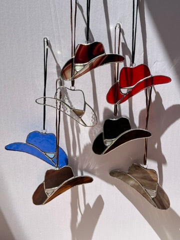 Colorful cowboy hats hanging against a white background
